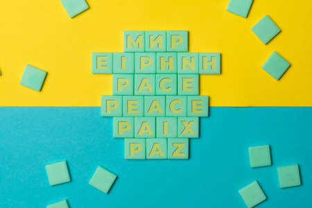 Plastic cards make up the inscription Peace in various languages on the Ukrainian flagの写真素材
