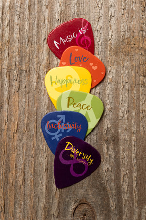 Power of music concept: five guitar picks with lgbtq colors with graphic and text for love happiness peace inclusivity and diversityの写真素材