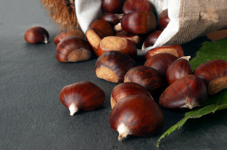 Close-up of chestnuts in jute basket on a rock tableの写真素材