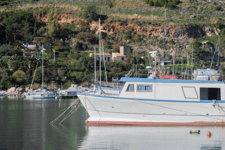 Small white fishing boat moored in portの写真素材