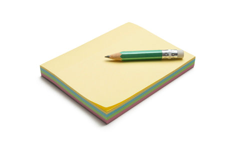 Block of colored sticky notes with a green pencilの写真素材