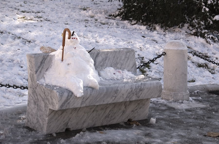Old snowman sitting on a benchの写真素材