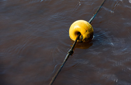 Yellow buoy on the water in the river. Selective focus.の写真素材