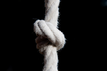 Rope tied with a knot on a black background close-upの写真素材