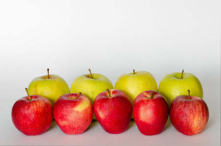 red and yellow apple in line with white backgroundの写真素材