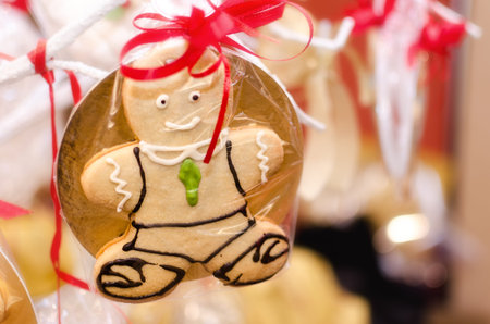 Closeup of a gingerbread man hanging trom a christmas tree as a decoration