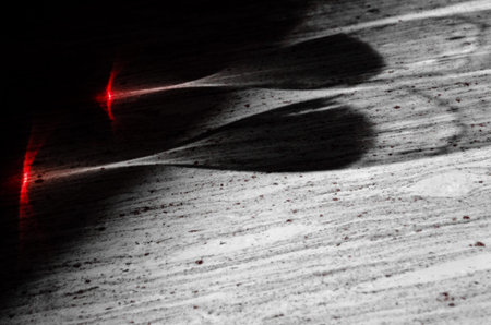Shadows of two glasses of Nebbiolo wine hit by sunlight on a marble table