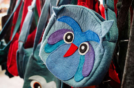 owl shaped handcrafted felt bag on a market stallの写真素材