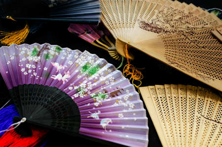 Many traditional chinese decorated fans on a tableの写真素材