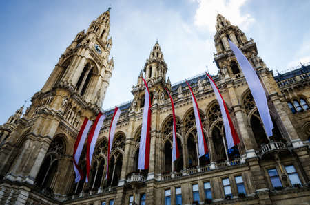 The Wiener Rathaus (Vienna City Hall, Austria) at sunset, with austrian flags over the facadeの写真素材