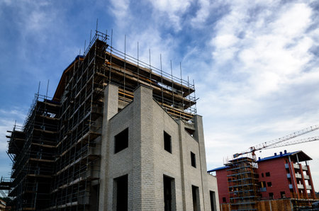 Building construction work yard with crane and cloudsの写真素材