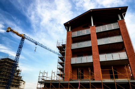 Building construction work yard with crane and cloudsの写真素材
