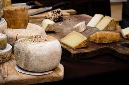 traditional pecorino cheese on a chopping board in a market stall in Italyの写真素材