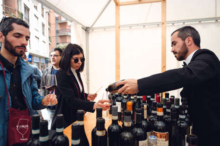 ALBA, ITALY - APRIL 25, 2019 â Sommelier and couple, with a woman tasting traditional red barbera wine of Piedmont at Vinum, wine e food show event of Alba, (Italy) on april 25, 2019のeditorial素材