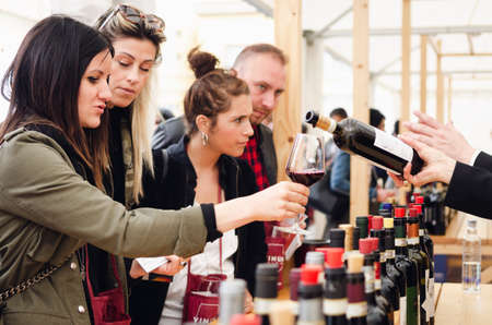 ALBA, ITALY - APRIL 25, 2019 â Sommelier and women tasting traditional red dolcetto wines of Piedmont at Vinum, wine e food show event of Alba, (Italy) on april 25, 2019のeditorial素材