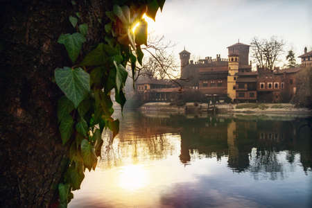 Turin (Piedmont, Italy), the river Po and the famous Borgo Medievale, neo-gothic castle in the Valentino public park at sunsetのeditorial素材
