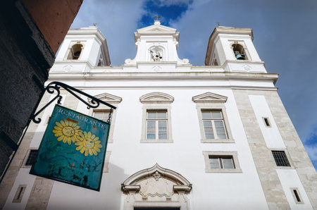 LISBON, PORTUGAL - FEBRUARY 2, 2019: Church of Sao Miguel and sign of a nearby typical restaurant in...