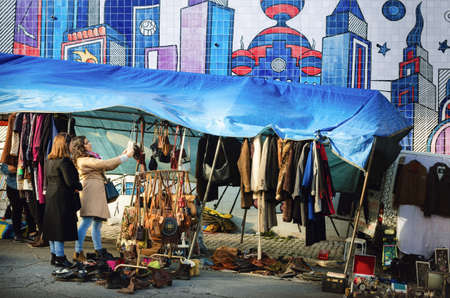 LISBON, PORTUGAL - FEBRUARY 2, 2019: woman looking on a stall of Feira Da Ladra, famous old flea street market in lisbon, portugal, on february 2, 2019のeditorial素材