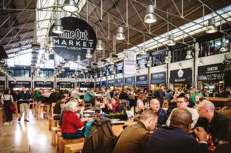 LISBON, PORTUGAL - FEBRUARY 3, 2019: People eating at the tables of the Time Out Market, famous...