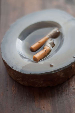 Ashtray with two cigarette in the waterの写真素材
