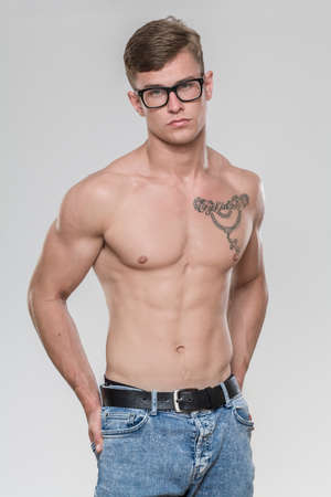 Studio portrait of a shirtless good looking young man. the model is serious and is looking at the camera.の写真素材