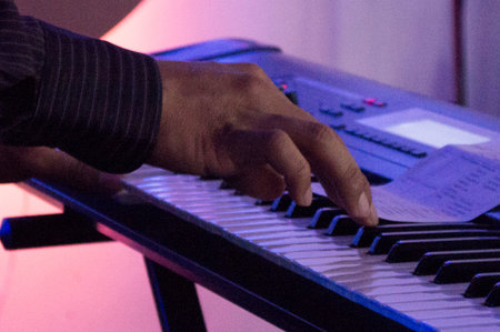 Hand playing the piano at a concert