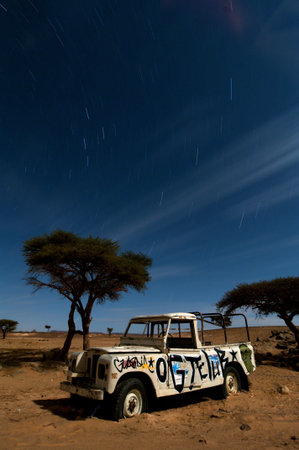 broken stranded off-road vehicle,  middle of the desert, by night, long exposureのeditorial素材