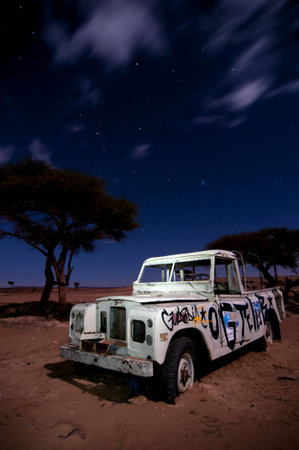 broken stranded off-road vehicle,  middle of the desert, by night, long exposureのeditorial素材