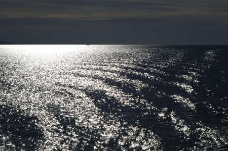 calm wavy rippeled white blue sea at sunriseの写真素材