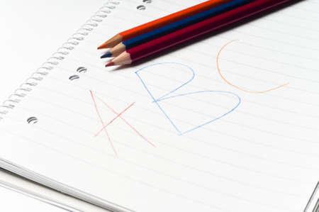 written white notebook with colored pencils の写真素材