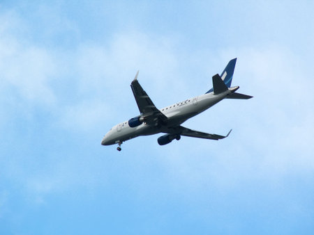 White plane descending, on blue sky background
