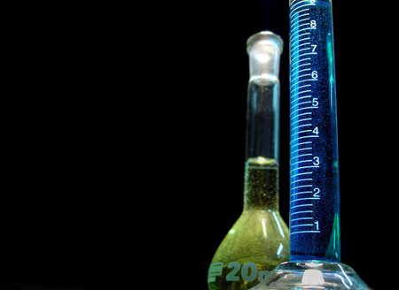 Glass cylinder and balloon used in chemistry laboratory isolated on black background