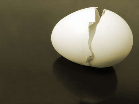 a broken egg shell on metallic background with reflectionの写真素材