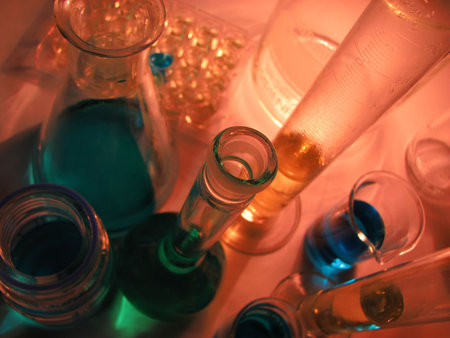Laboratory glassware on red background in low light