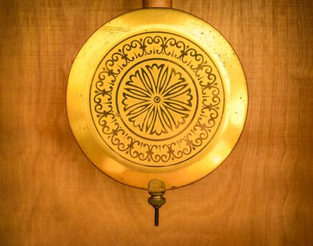 Golden pendulum from a vintage clock made in Russia former USSR (Soviet Union).の写真素材