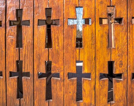 Wooden fence with christian crosses carved in it. Fence of a orthodox church in Romania.の写真素材