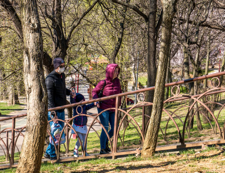Bucharest/Romania - 03.17.2020: Family in the park wearing face mask for protection against Coronavirus.のeditorial素材