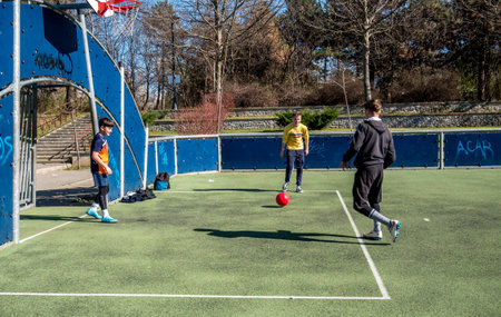 Buchares/Romania - 03.17.2020: Young men playing soccer on a synthetic field in in Alexandru Ioan Cuza Park park or Titan parc. Football on a sunny day.のeditorial素材