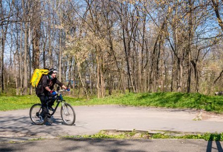 Bucharest/Romania - 03.19.2020: Glovo courier on a bike delivering food.のeditorial素材