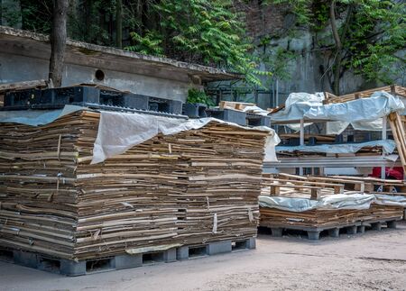 Stacked Carboard Boxes ready for recycling on black plastic pallets.の写真素材
