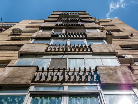 Worn out apartment building from the communist era against blue sky in Bucharest Romania. Ugly traditional communist housing ensembleの写真素材