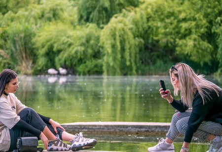 Bucharest/Romania - 05.23.2020: Two young girls taking pictures of each other in the Youth Park, Bucharest.のeditorial素材