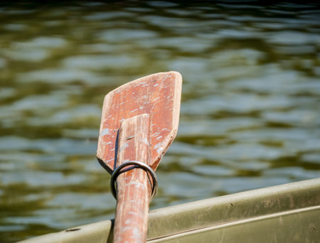 Close up with an oear of a boat or a paddle on a lake.