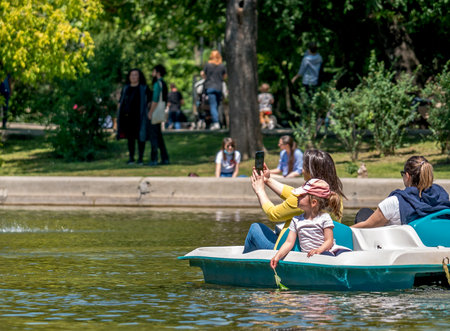 Bucharest/Romania - 05.30.2020: Crowded park after coronavirus pandemic. Mother with kids in a boat, in Cismigiu park.のeditorial素材