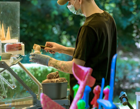 Bucharest/Romania - 05.30.2020: Man serving ice cream.Ice-cream seller putting scoop of ice-cream on a cone.のeditorial素材