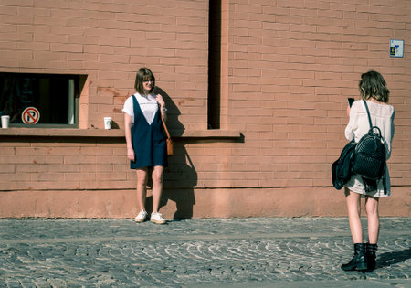 Bucharest/Romania - 05.30.2020: Two girls in the old town of Bucharest. taking pictures or posing to each other.のeditorial素材