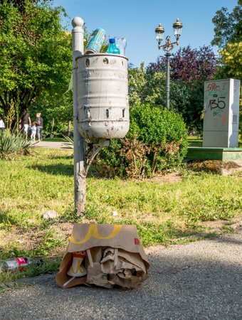 Bucharest/Romania - 05.30.2020: Garbage bin full of trash. Overflowing garbage bin in a park in Bucharest.. Peaople leaving garbage near the bin.のeditorial素材