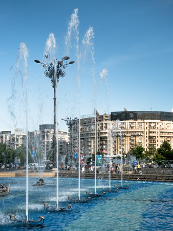 Bucharest/Romania - 05.30.2020: Unirii Square in the center of Bucharest with water fountains and buidings against clear blue sky.のeditorial素材