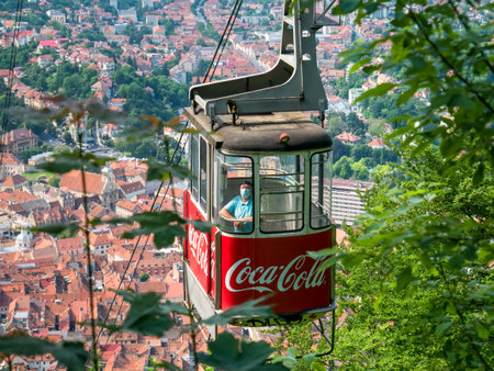 Brasov/Roamania - 06.28.2020: Man wearing a face mask in a cable car. Cable car with the city of Brasov in the background.のeditorial素材