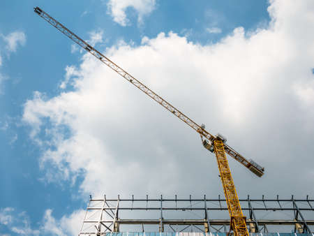 Construction crane or building crane on a construction site against blue skyの写真素材